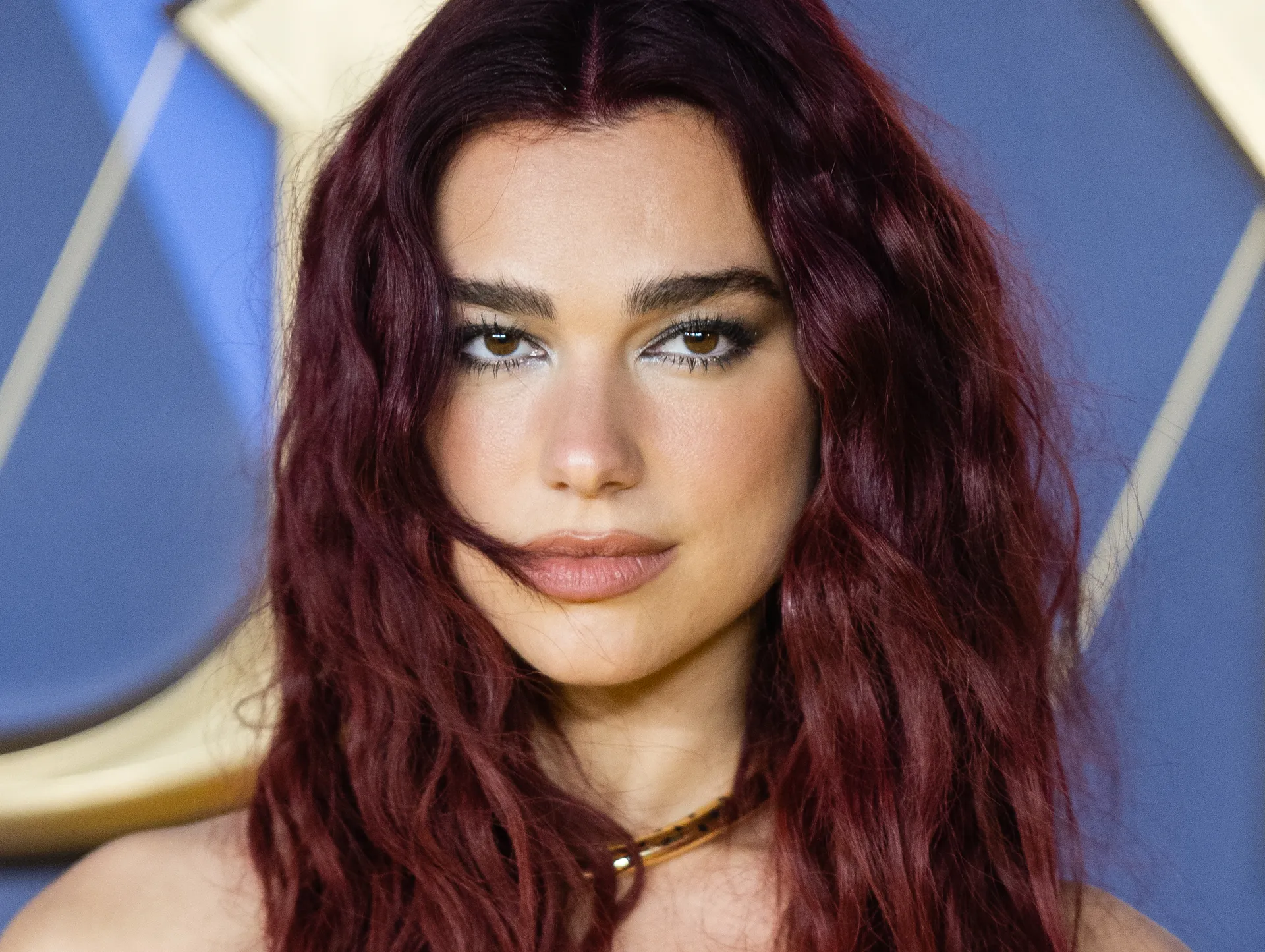 Dua Lipa Radiates Star Power in a Glamorous Magenta Ensemble and Tousled Waves Eagerly embracing the allure of drama.